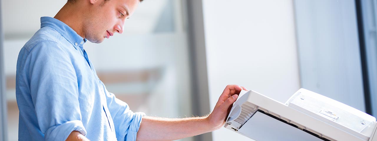 Man using a copier in a bright office Copier Rentals